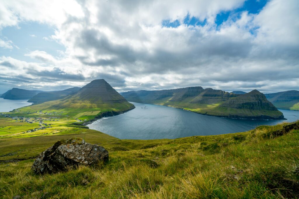 Breathtaking aerial view of verdant hills and ocean in the Faroe Islands.